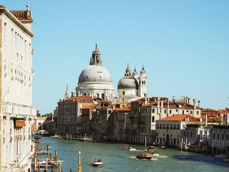 Venice Travel Guide: 12 Best Things to Do, Where to Stay & Insider Tips Grand Canal in Venice with water taxis and the domes of Santa Maria della Salute