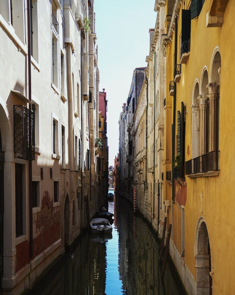 Narrow canal between tall historic buildings in a quiet corner of Venice