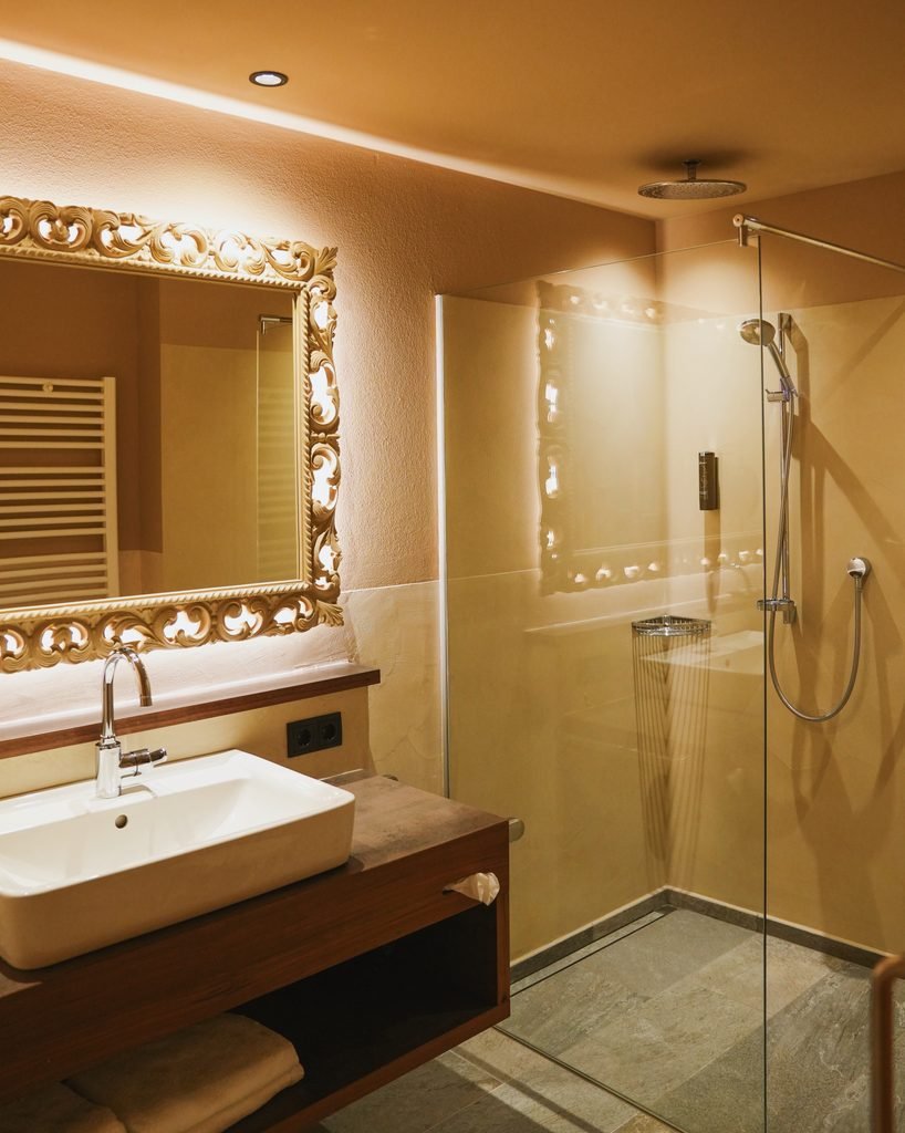 Deluxe Suite bathroom at Hotel Masl with a walk in rain shower and an ornate mirror