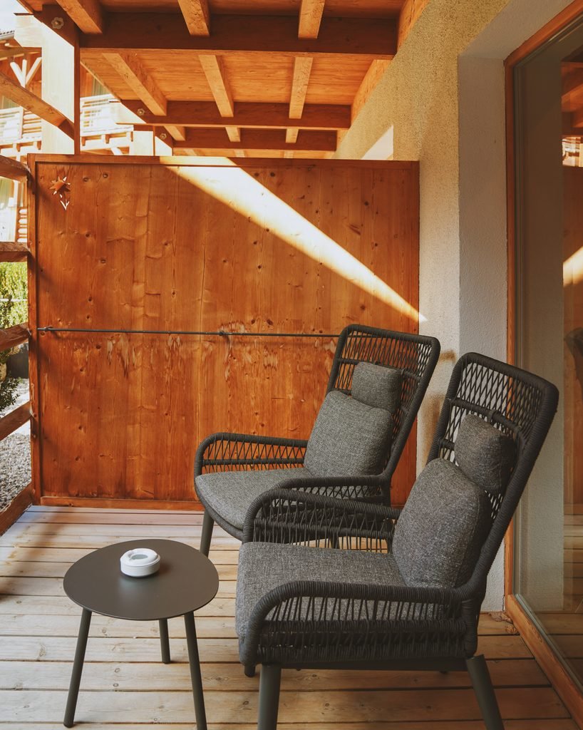 Private wooden balcony with two outdoor armchairs in the Deluxe Suite at Hotel Masl