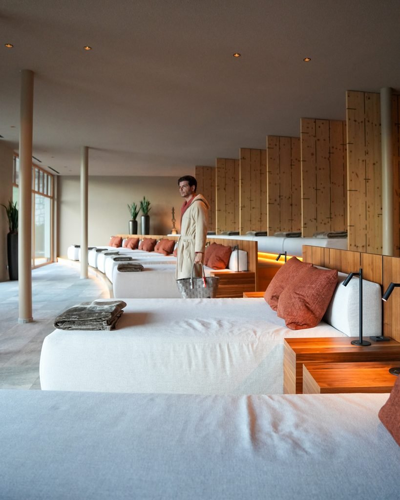 Daniel in a bathrobe in the panoramic relaxation room at Hotel Masl spa with rows of loungers